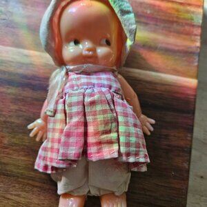 Vintage Irwin  Kewpie Doll is dressed and has a bonnet and is marked on back